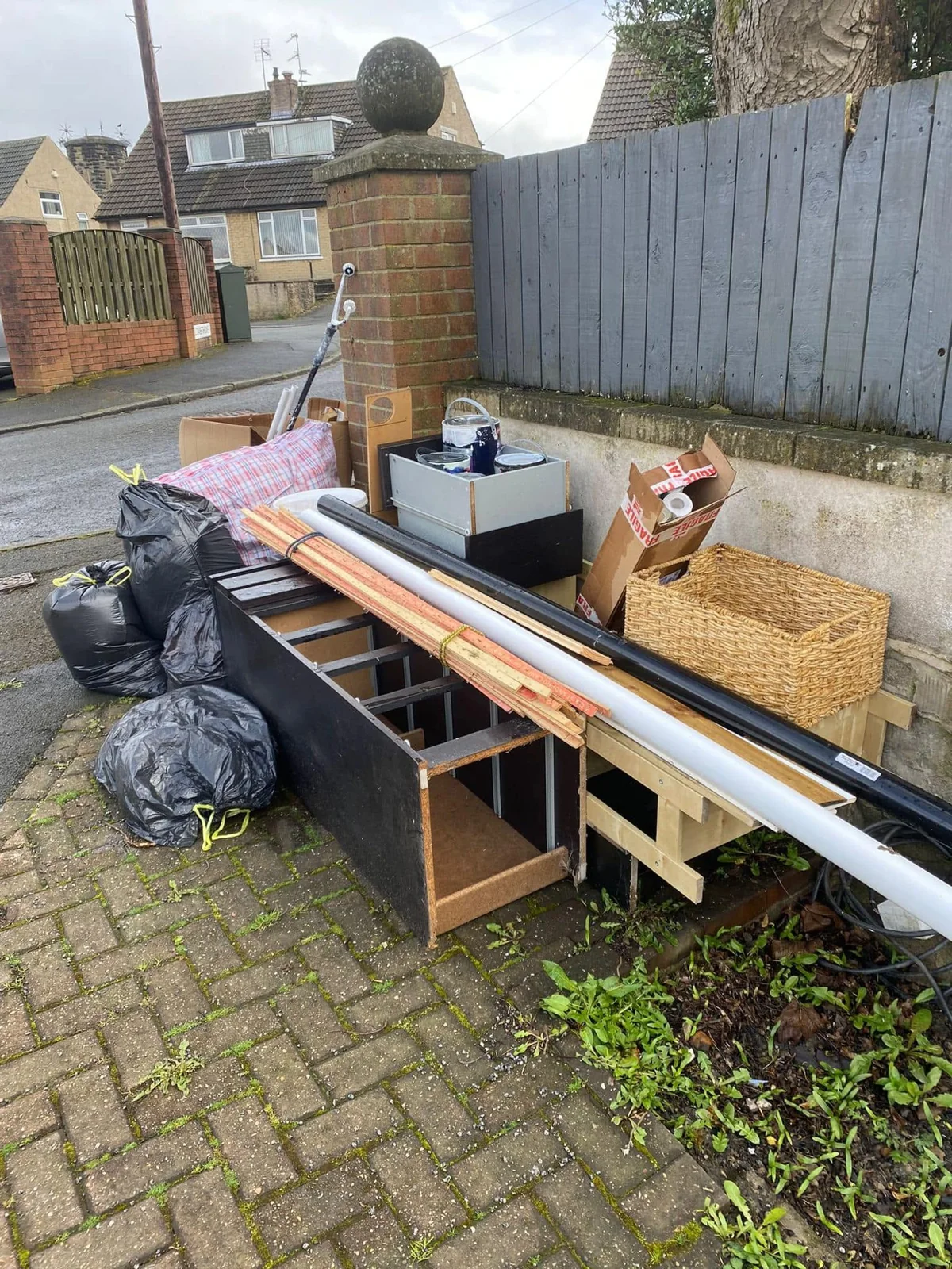 Timber, shelving and bags grouped outside a home for clearance