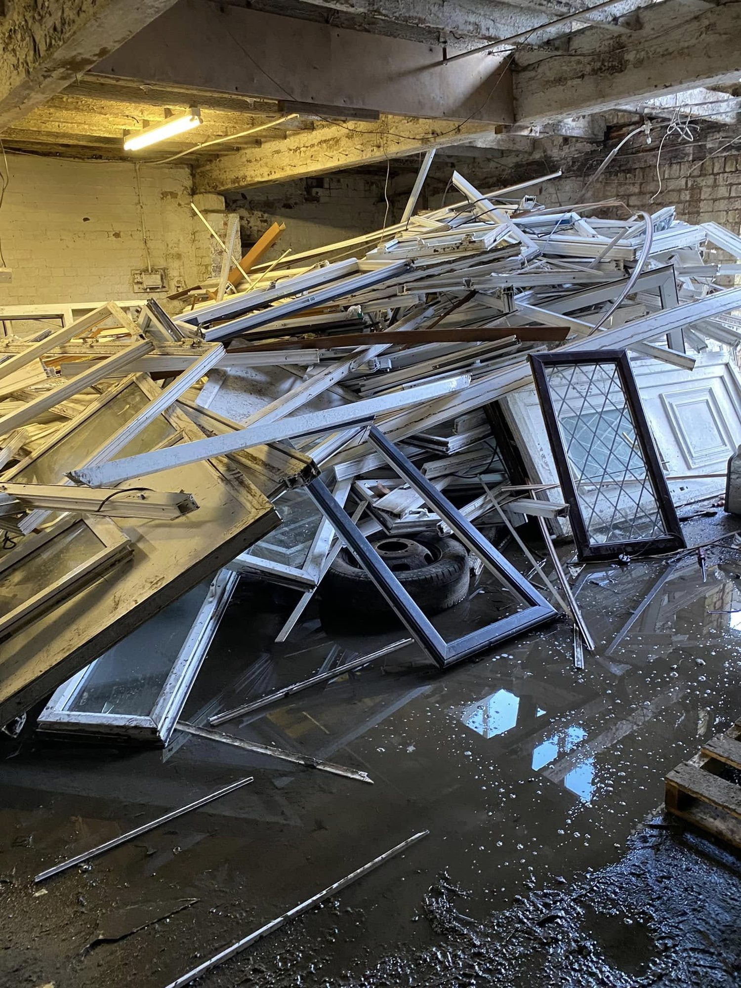 Discarded window frames and building materials inside a room