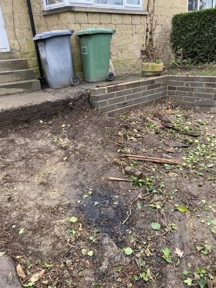 Garden ground beside a house and wheelie bins