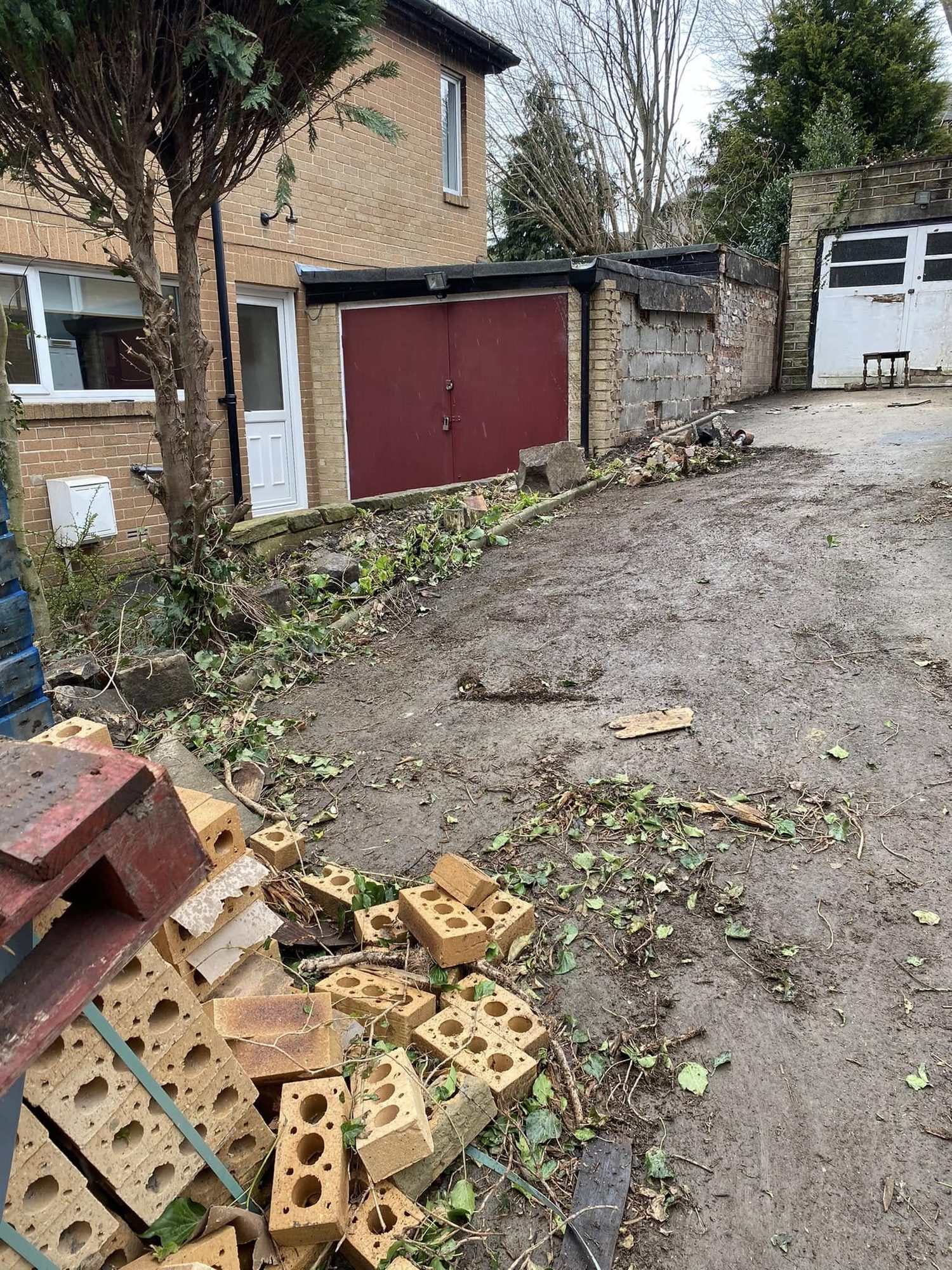 Loose bricks and demolition rubble beside garages