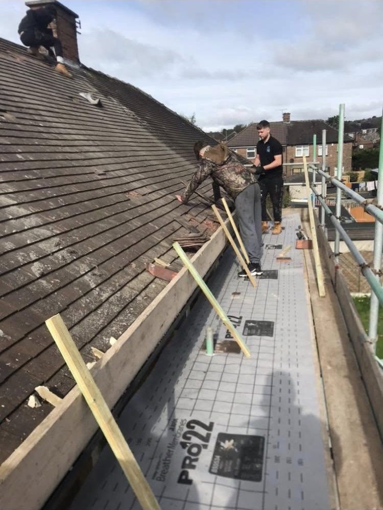 Workers removing roof materials on scaffolding