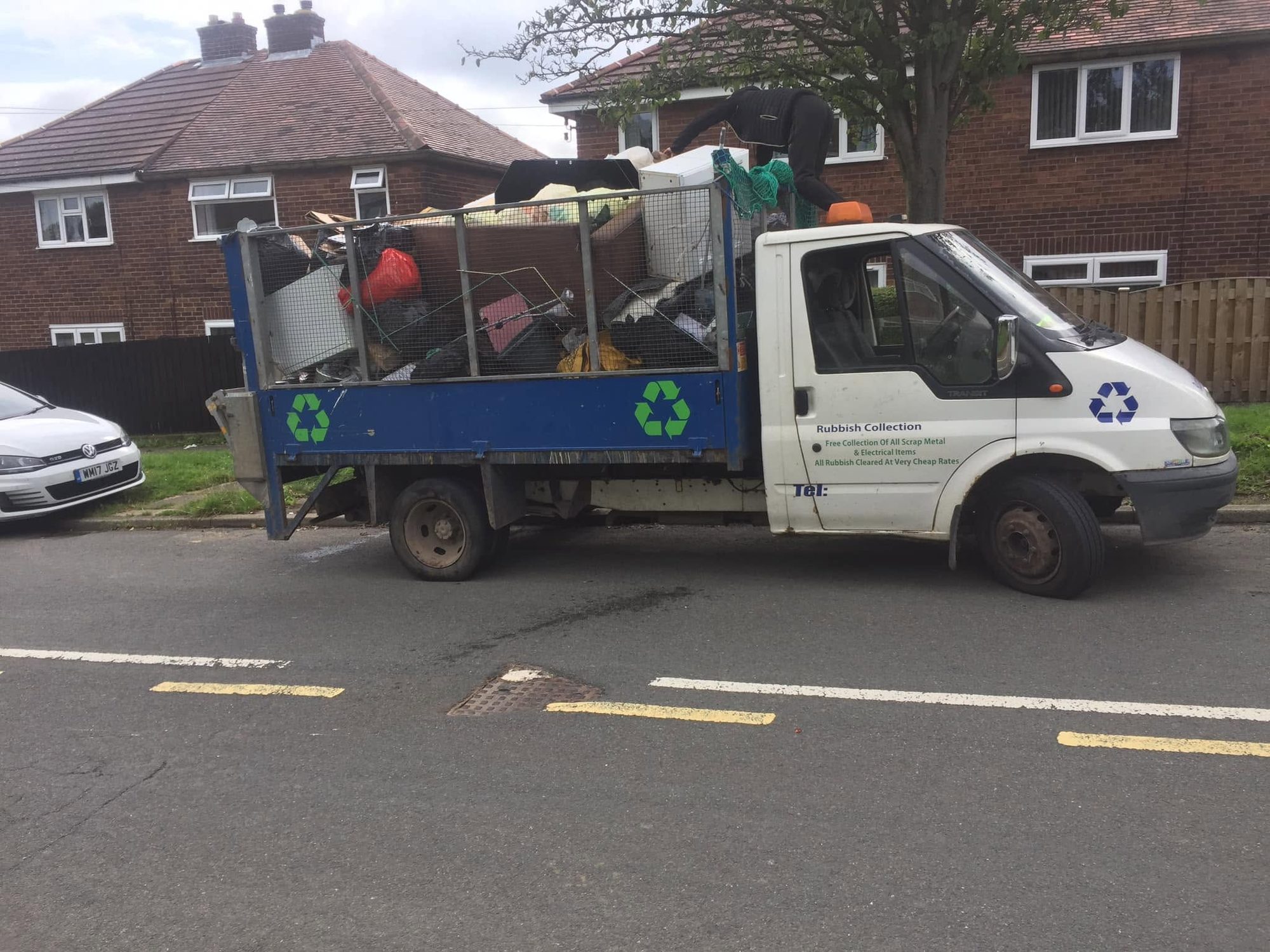Waste truck loaded with household rubbish outside residential houses