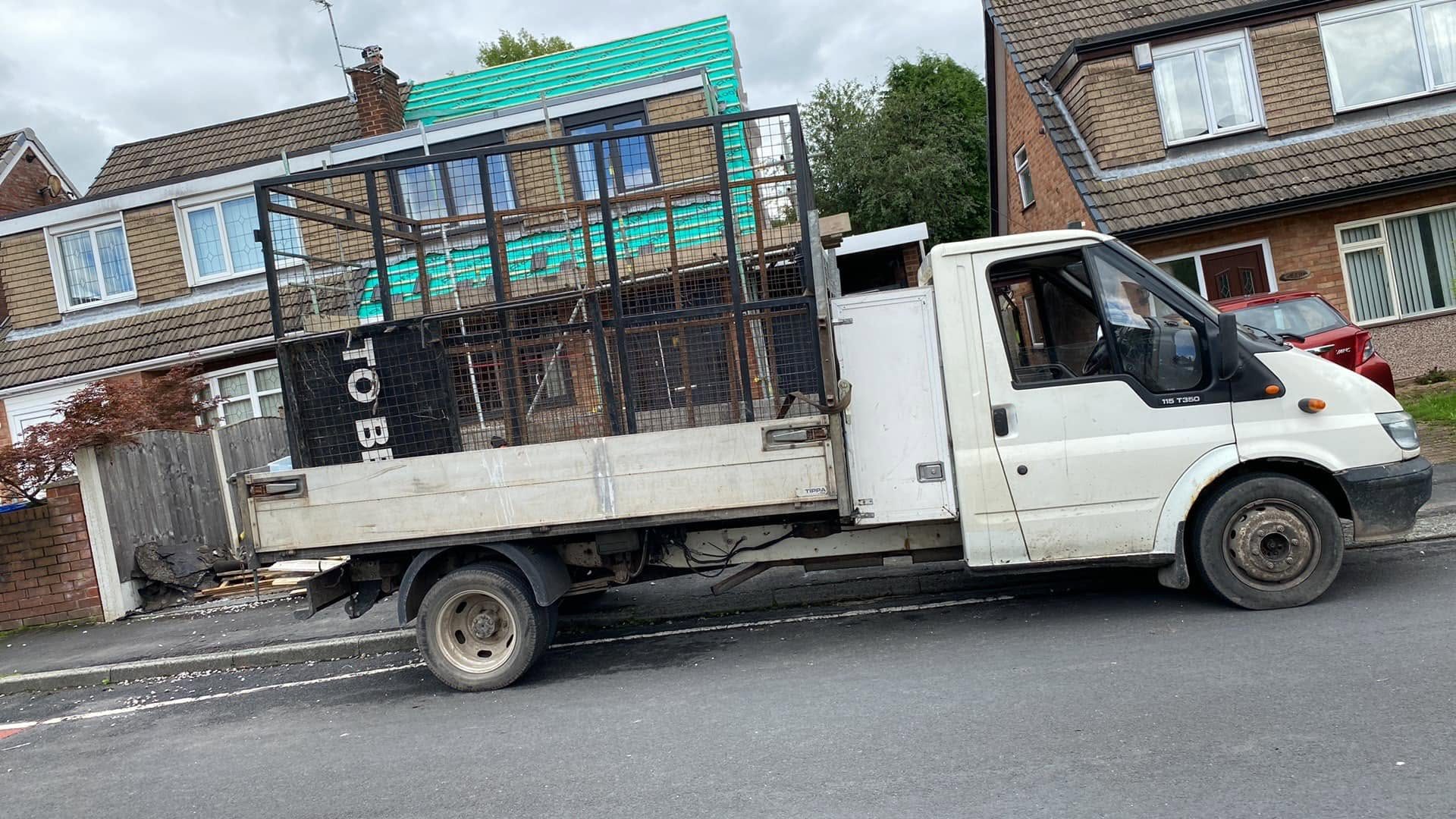 White waste collection truck on a residential street