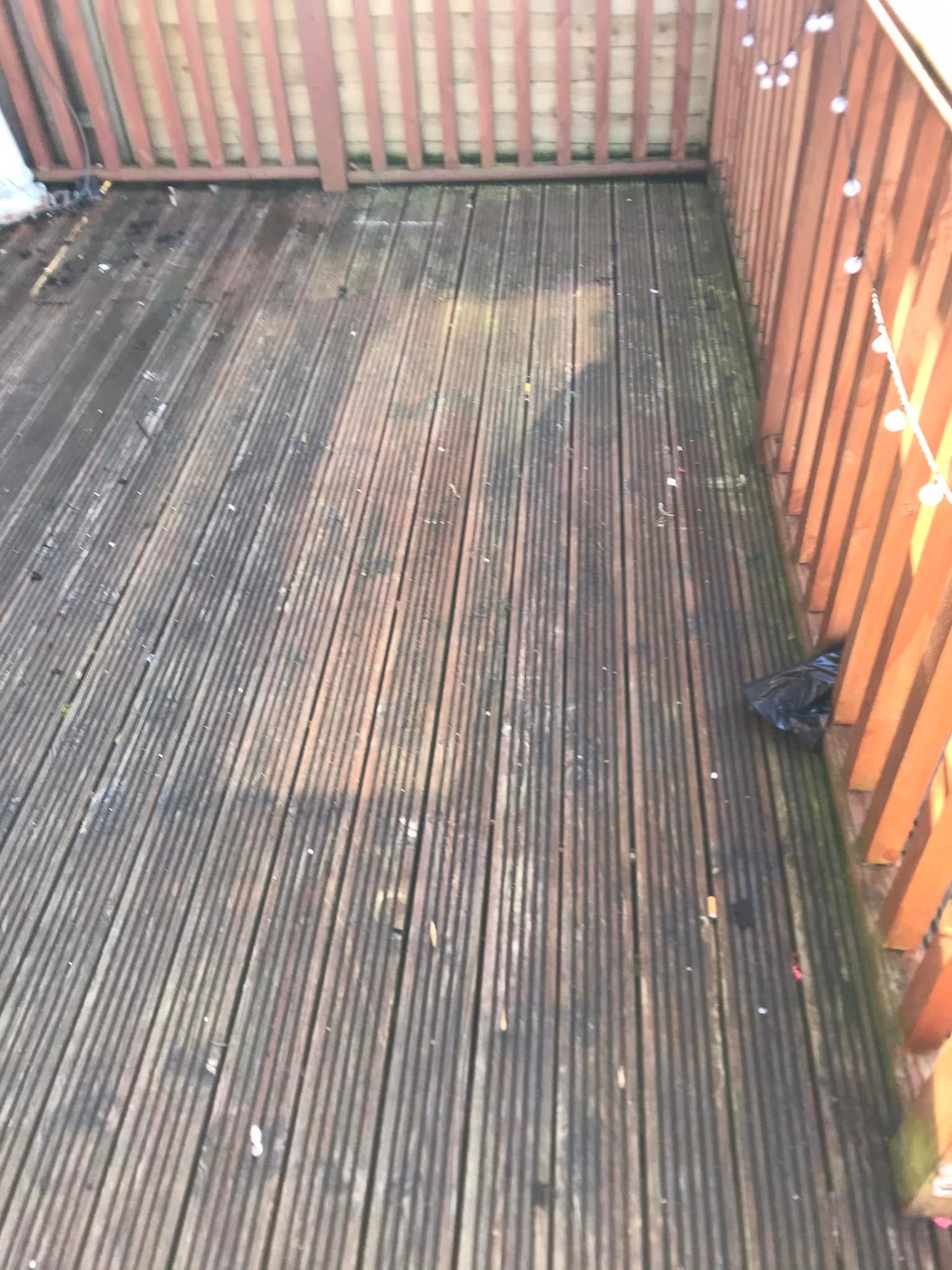 Weathered timber decking beside a fence